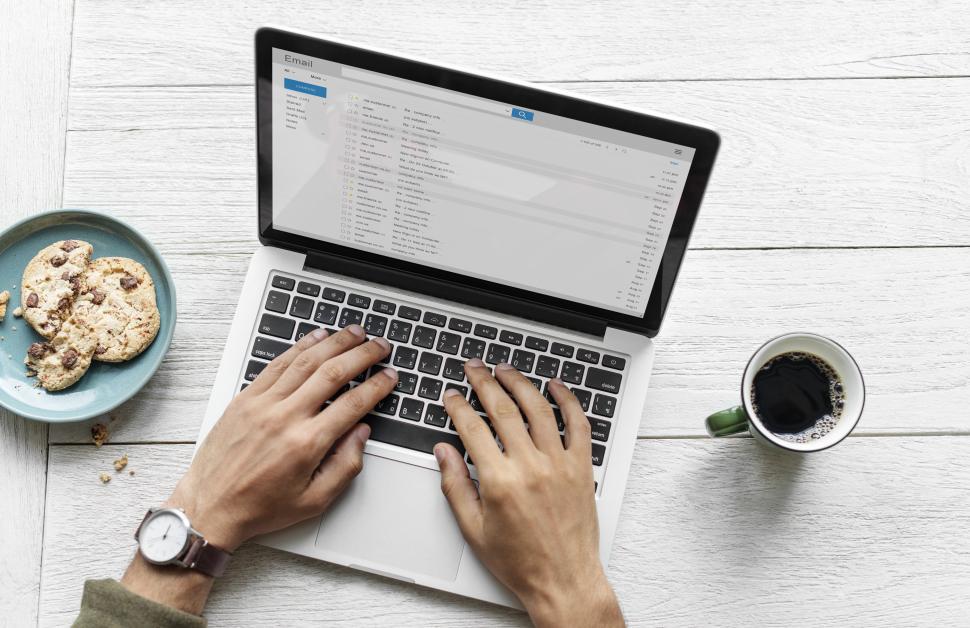 Free Image of A person typing on modern laptop with cookies 