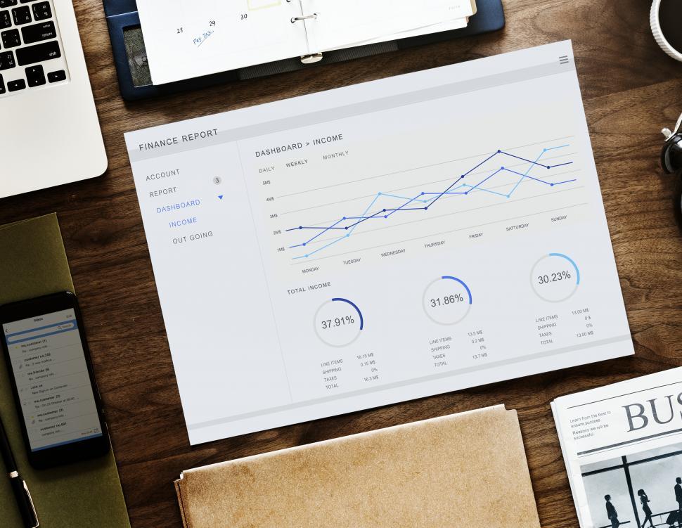 Free Image of Flat lay of a laptop along with charts on the office table 