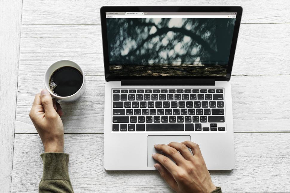 Free Image of Overhead view of a hands on laptop with black coffee 