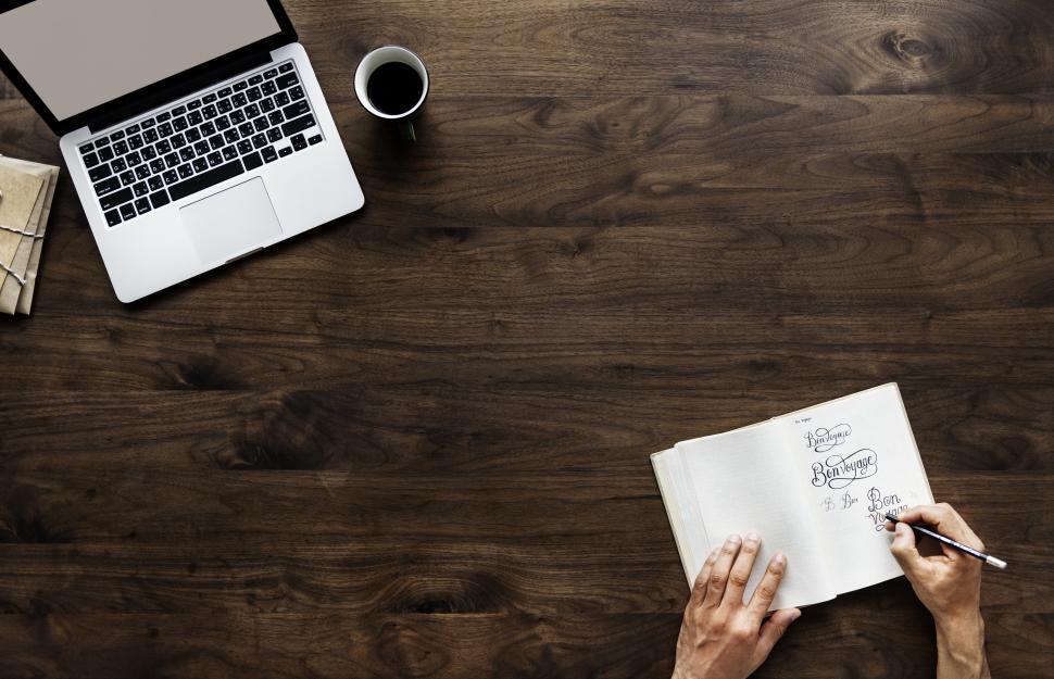 Free Image of Overhead view of hands writing on a notebook with copyspace 
