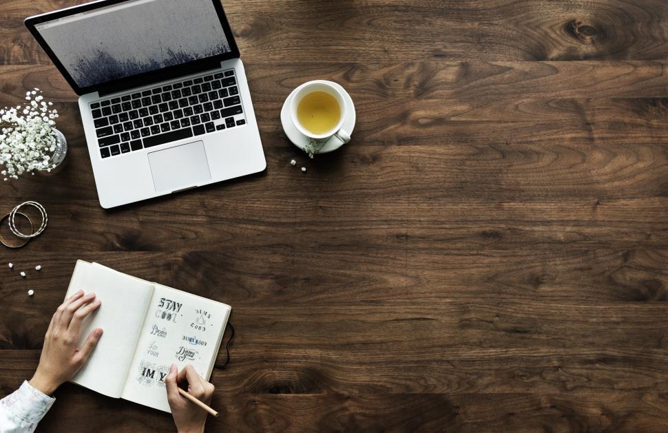 Free Image of Overhead view of hands writing on a notebook - copyspace 
