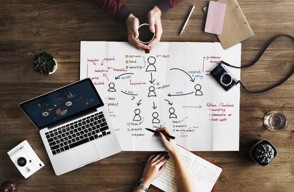 Free Image of Flat lay of a laptop and a coffee mug with an org chart illustration 