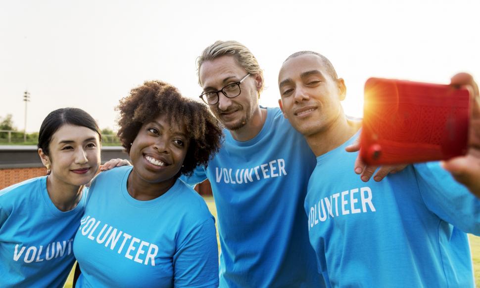 Free Image of A group of volunteers taking a group photograph with mobile phone 
