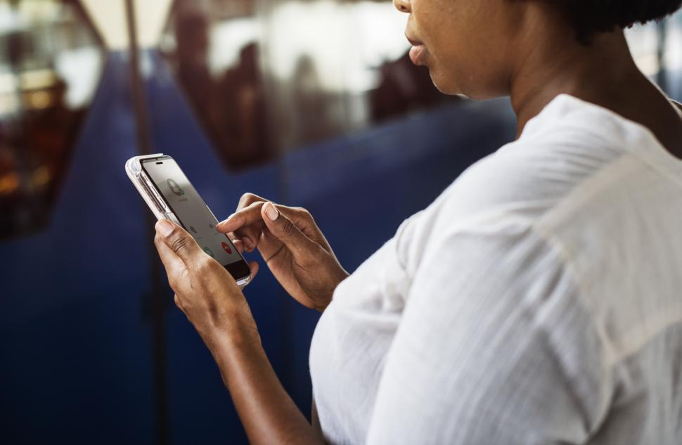 Free Image of A woman looks at her mobile phone, answering a call 