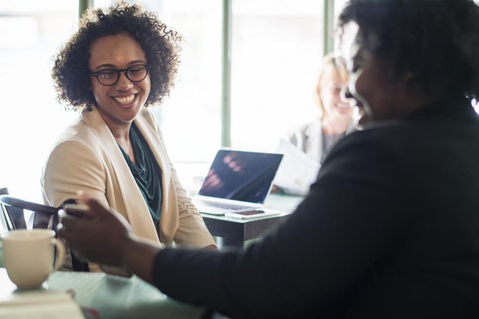 Free Image of Two businesswomen at a cafe laughing 