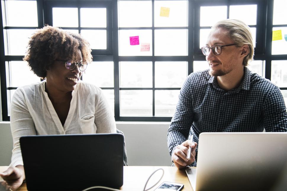Free Image of Two colleagues working side by dice 