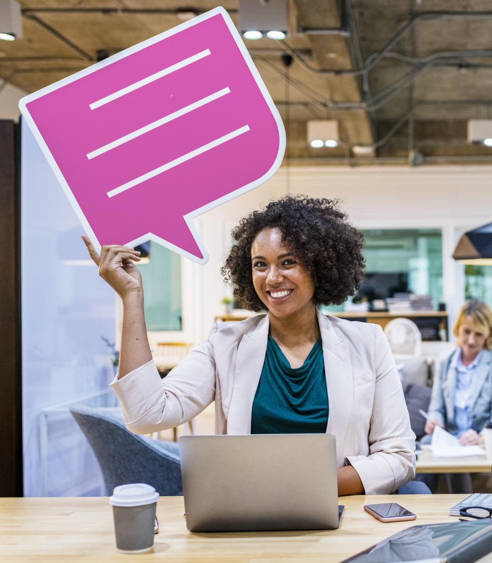 Free Image of A young African ethnicity woman with curly hair holds a speech bubble cardboard cutout 
