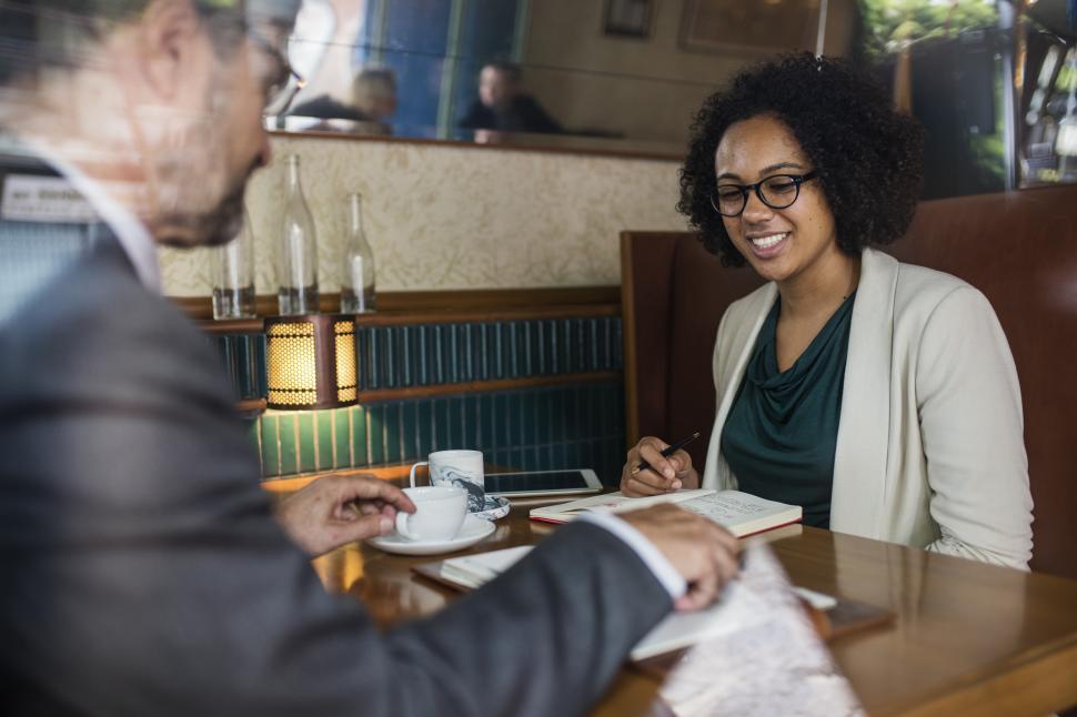 Free Image of A senior man and a young female colleague at a cafe 