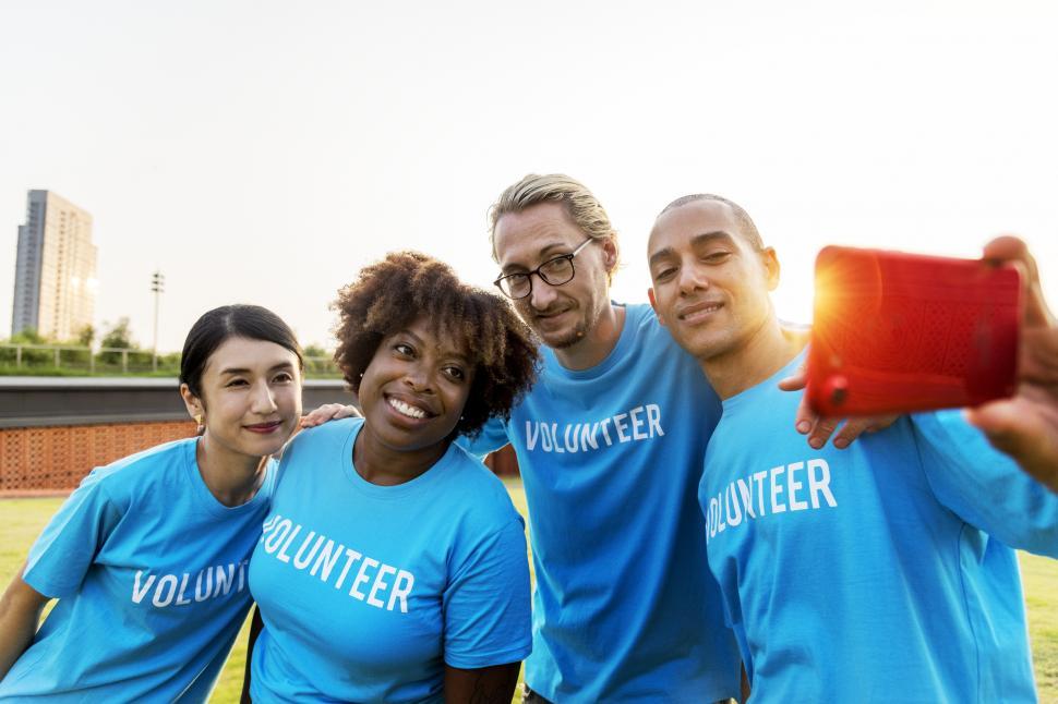 Free Image of A group of multiethnic volunteers taking a group photograph with mobile phone 