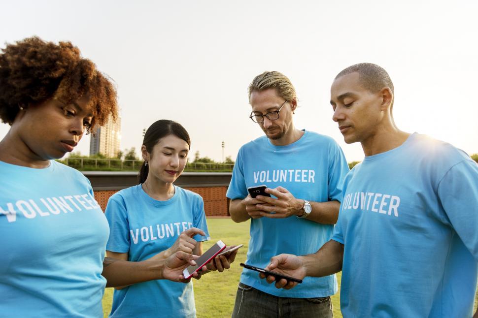 Free Image of A group of multiethnic volunteers looking at their mobile phones 