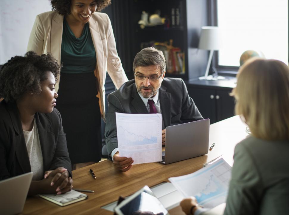 Free Image of Two young women in working in the office along with an older man 
