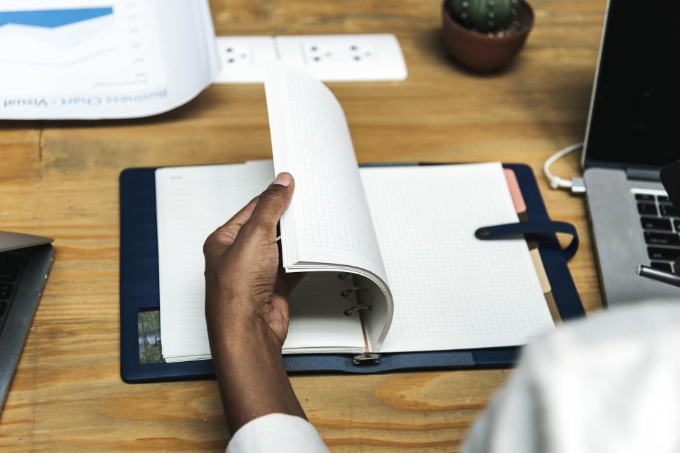 Free Image of Close up of a woman s hand turning the page of a planner 