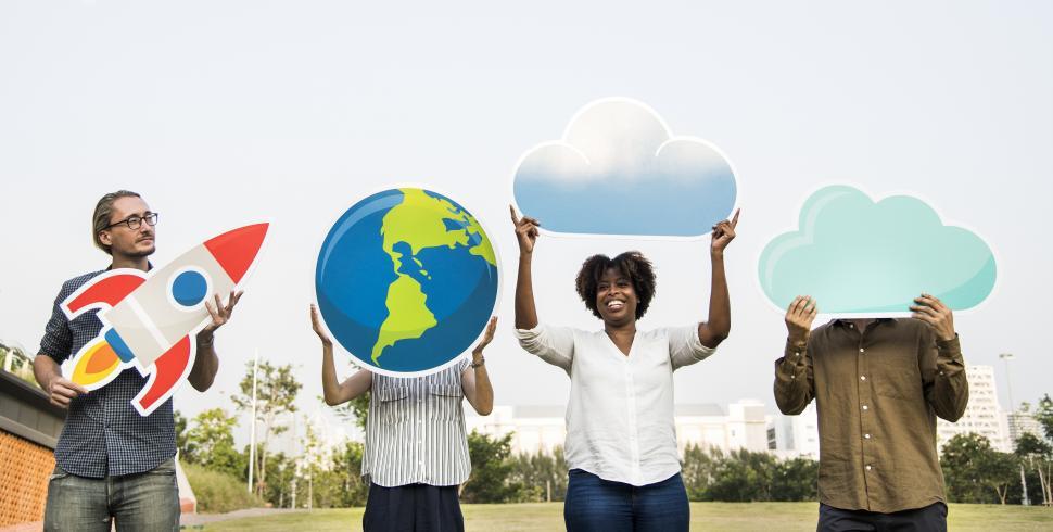 Free Image of A group of people posing with a globe, a rocket and cloud shaped cardboard cutouts 