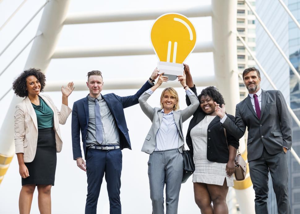 Free Image of Colleagues posing with a lightbulb symbol cardboard cutout 