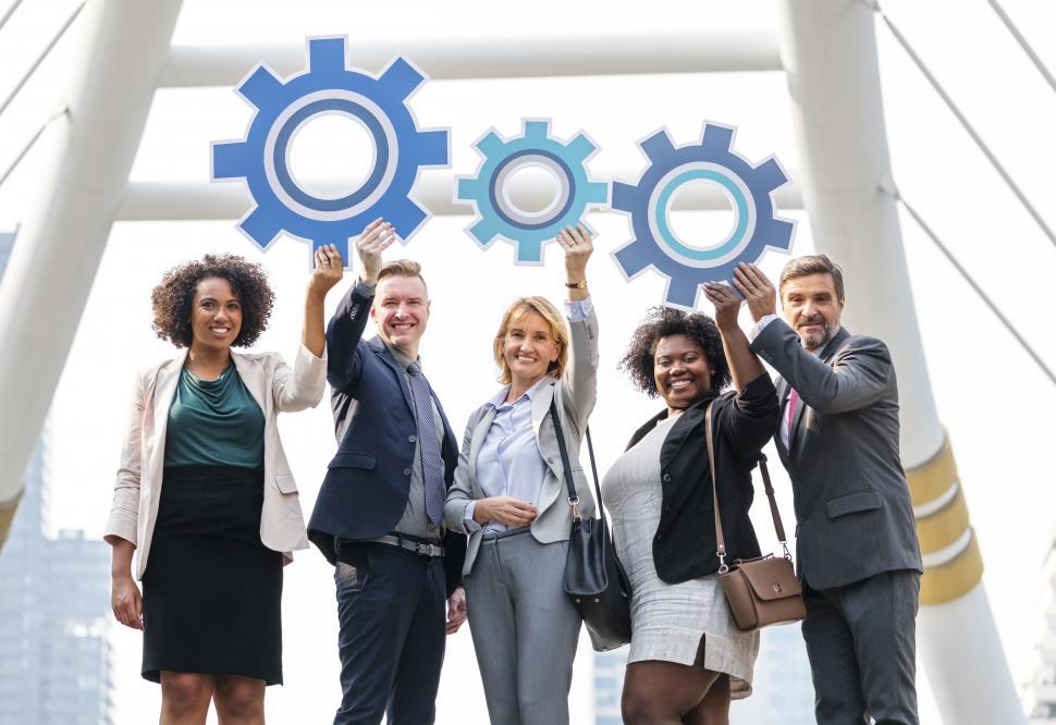 Free Image of Colleagues posing with gear shaped cardboard cutouts - teamwork 
