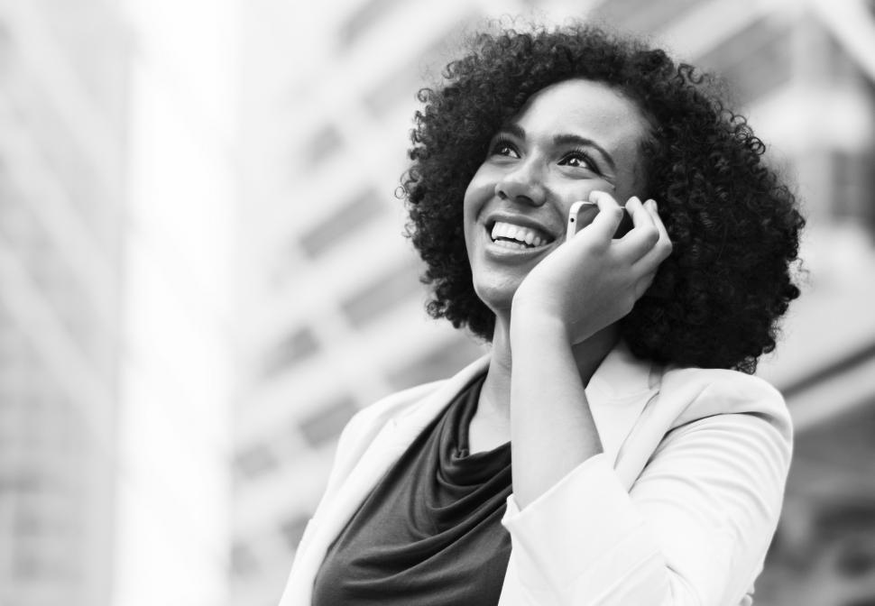 Free Image of Black and white photo of woman speaking on a mobile phone 