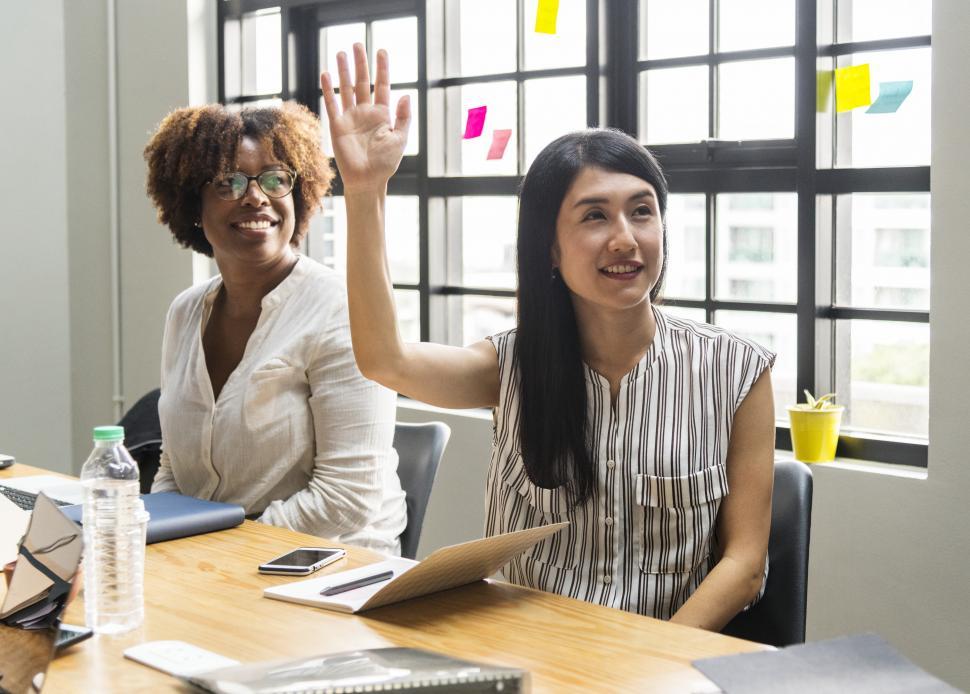 Free Image of An woman raising her hand to ask a question at a meeting 