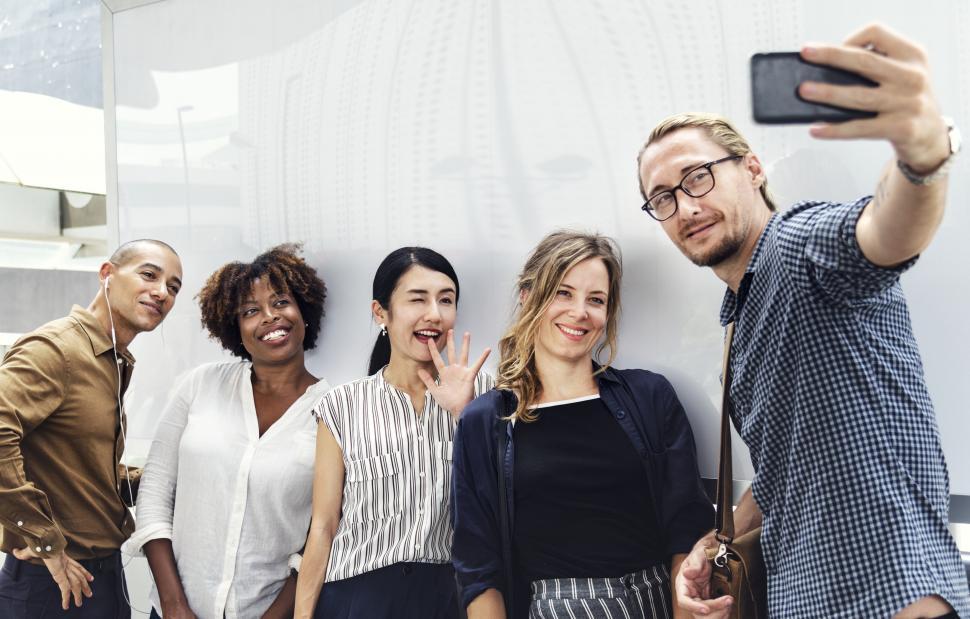 Free Image of A group of multiethnicity colleagues taking a group selfie with smartphone 