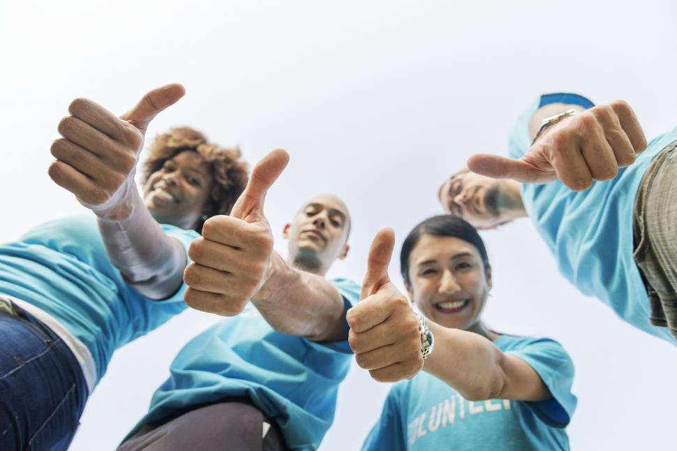 Free Image of Low angle view looking up at a volunteer group thumbs up 