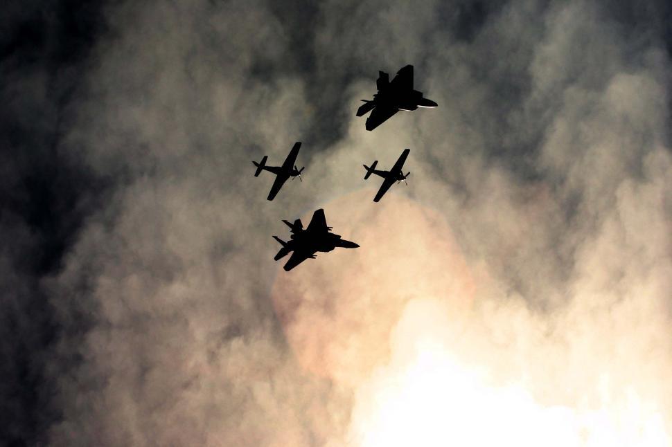 Free Image of Airshow planes silhouetted against dramatic sky 