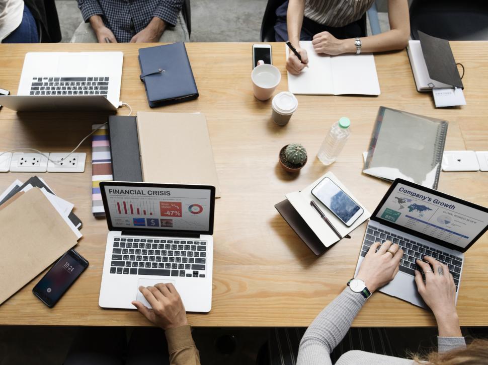 Free Image of Overhead view of a crowded meeting table in the office 