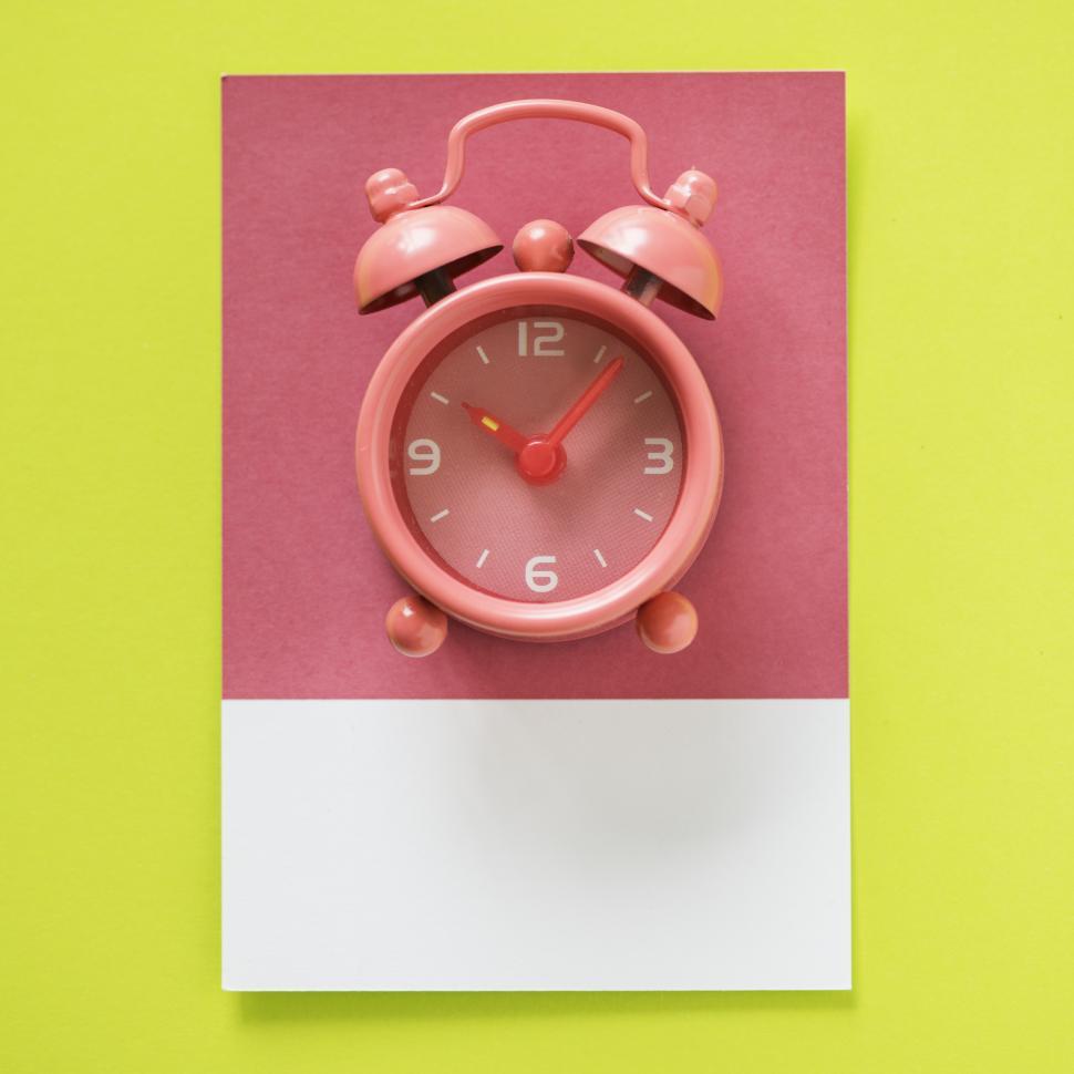 Free Image of Flay lay of a miniature alarm clock on matching cardboard frame 
