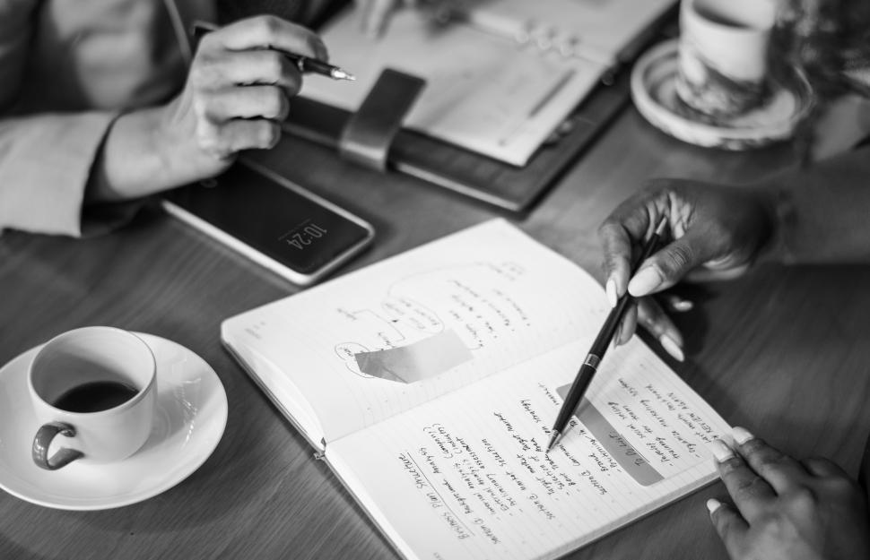 Free Image of Close up of a womans hand taking notes at a cafe 