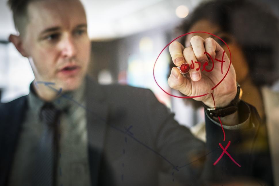 Free Image of A young Caucasian businessman drawing a diagram on the glass panel 