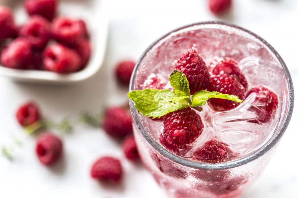 Free Image of Close up of a glass of chilled beverage garnished with raspberries 