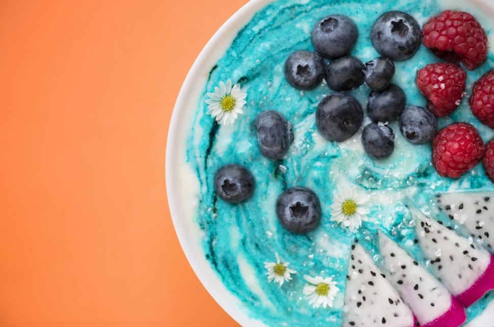 Free Image of Close up blueberries, raspberries and dragon fruit slices served in a plate 
