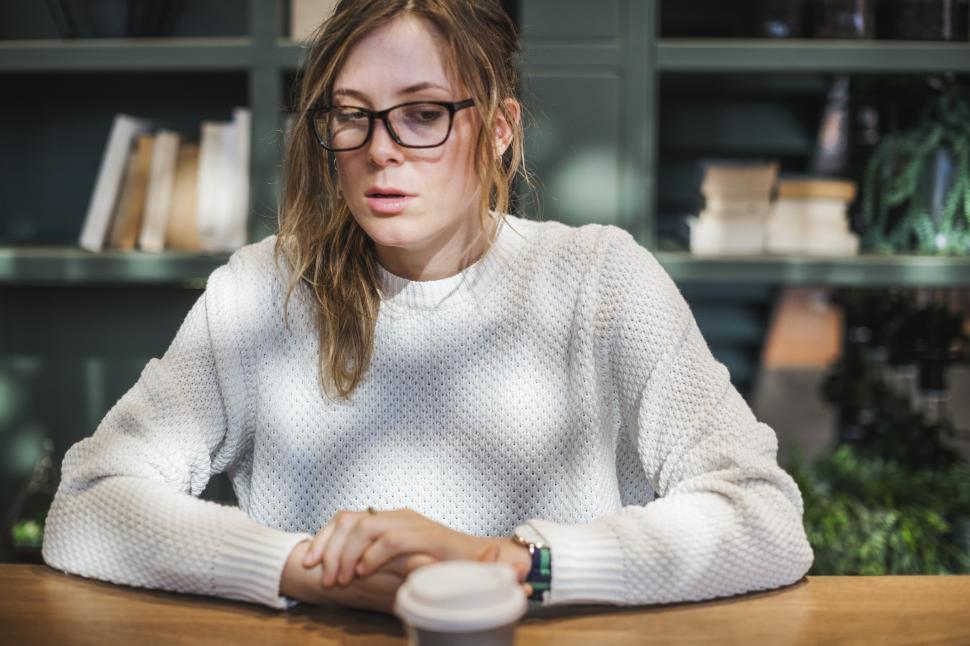 Free Image of A young Caucasian woman at a table in a cafe 