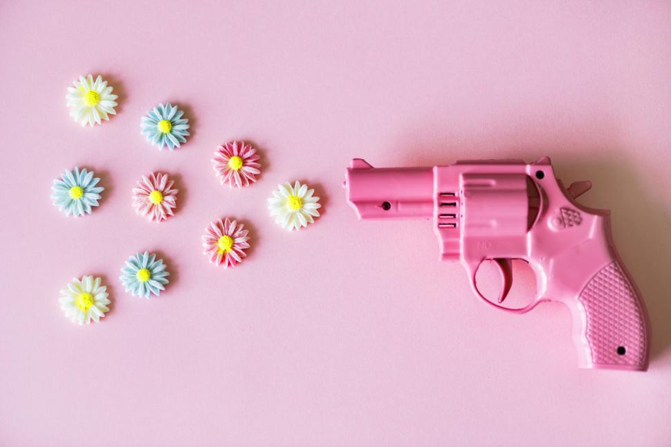 Free Image of Flat lay of clay flowers depicted as being fired from a toy gun 