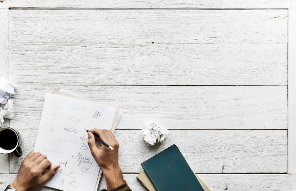 Free Image of Overhead view of a person writing calligraphy with copyspace and crumpled paper 