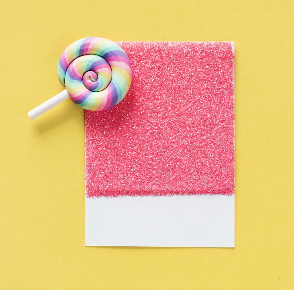 Free Image of Flat lay of a candy lollipop on a spaced cardboard frame 