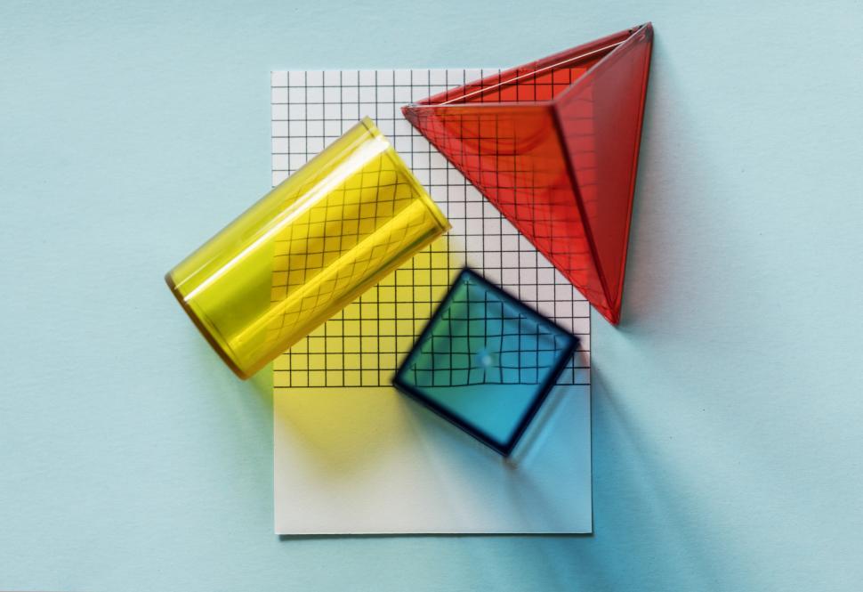 Free Image of Flat lay of glass geometrical shapes on spaced cardboard frame 