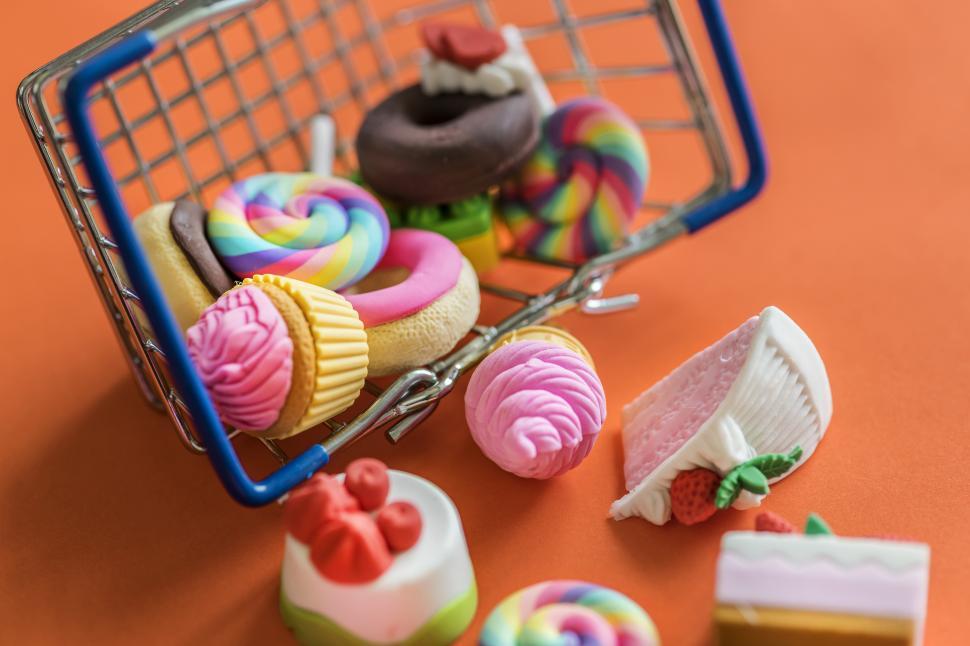 Free Image of Close up of fake sweets and candies fallen out of a steel wire basket 