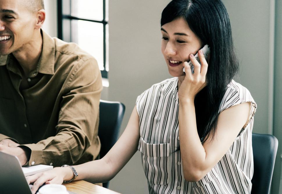 Free Image of A woman speaking on her mobile phone at the office 