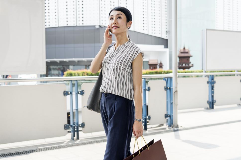 Free Image of An Asian woman calling on her mobile phone 