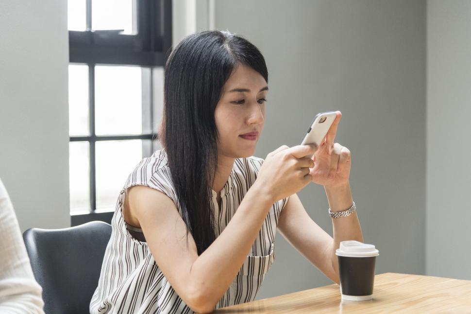 Free Image of An Asian ethnicity woman operating her mobile phone 