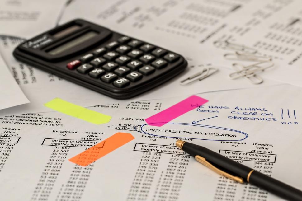 Free Image of Calculator on Top of Pile of Papers 