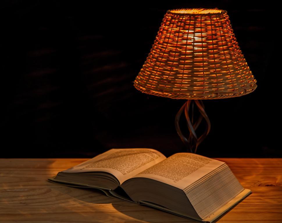 Free Image of Open Book on Table Beside Lamp 