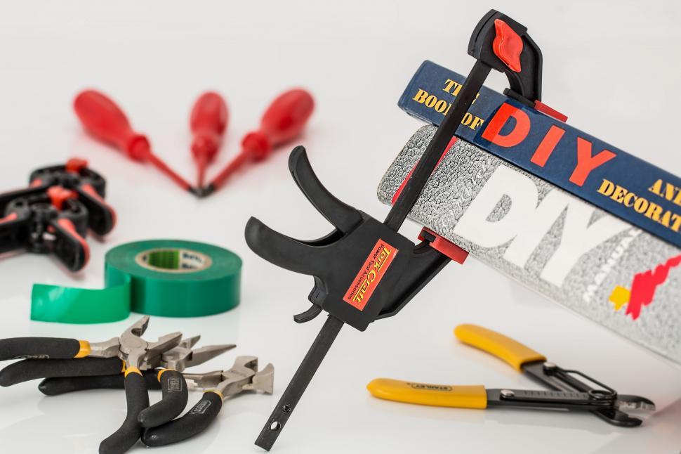 Free Image of Assorted Tools Including Pliers, Tape, and Scissors on a Table 