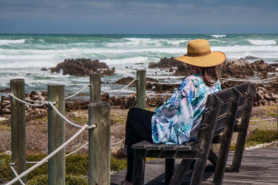 Free Image of Woman Sitting on Bench by Ocean 