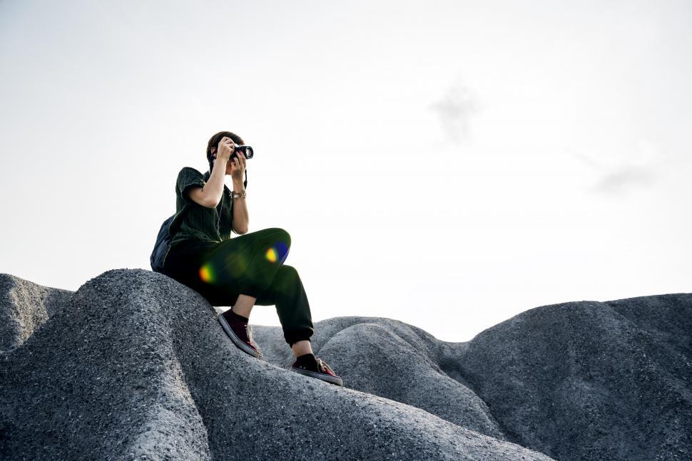 Free Image of A young caucasian woman taking photo on a bumpy hike 