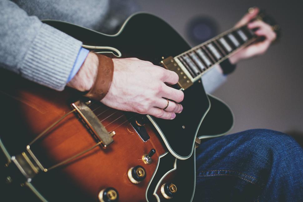 Free Image of Young man playing guitar - face not seen 