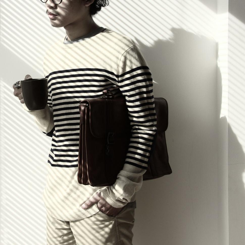 Free Image of Man with laptop bag and coffee mug - Light and Shadow  