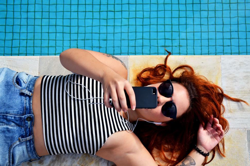 Free Image of Woman lying down near swimming pool 