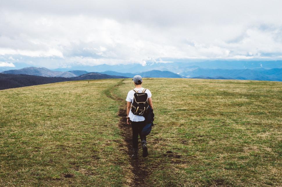 Free Image of Man Walking on grass field  