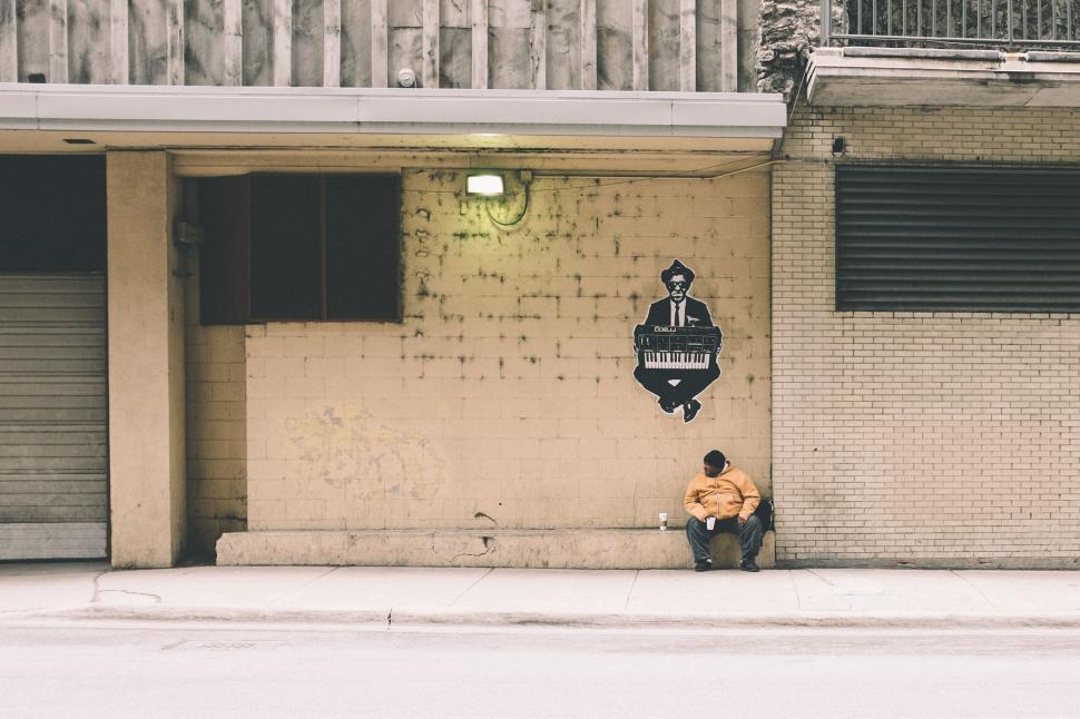 Free Image of Middle Aged Man Sitting on Pavement  