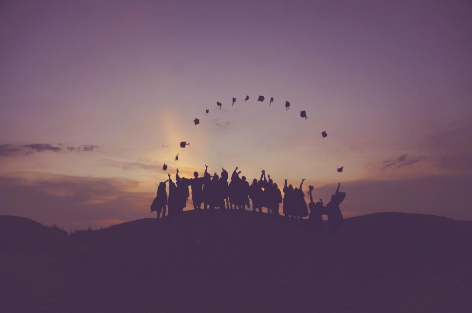 Free Image of Silhouettes of people throwing hats in the air 